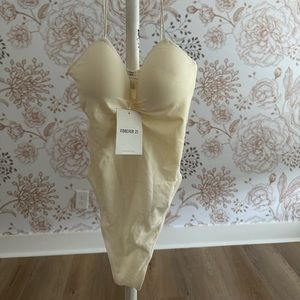 Never worn cream colored body suit with lined cups